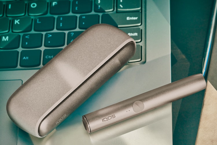 IQOS ILUMA držač i džepni punjač na tipkovnici laptopa.