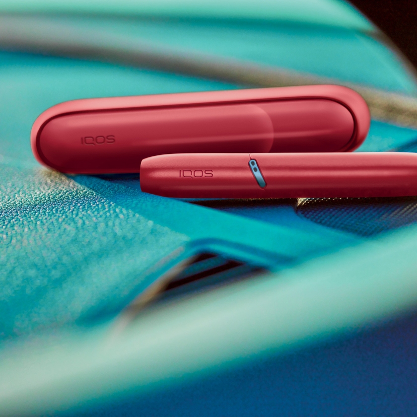 Red IQOS Originals Duo heated tobacco device with HEETS stick and case.