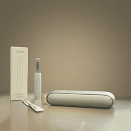 Gold IQOS Device beside IQOS Cleaning Tool