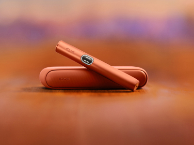 Red  IQOS ILUMA i device above its charger