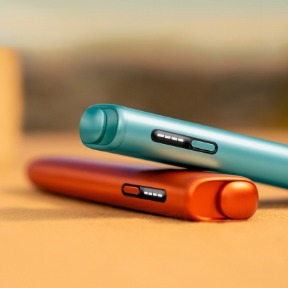 Blue IQOS ILUMA i ONE above a terracotta IQOS ILUMA i ONE