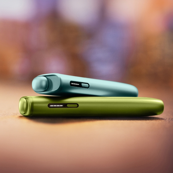 Blue IQOS ILUMA i ONE above a green IQOS ILUMA i ONE
