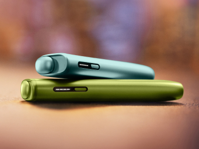 Plavi IQOS ILUMA i ONE uređaj na zelenom IQOS ILUMA i ONE uređaju