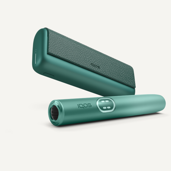 Aspen Green IQOS ILUMA i PRIME device below its charger