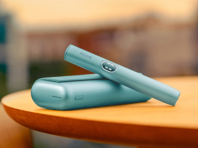 Blue IQOS ILUMA i PRIME device above its charger