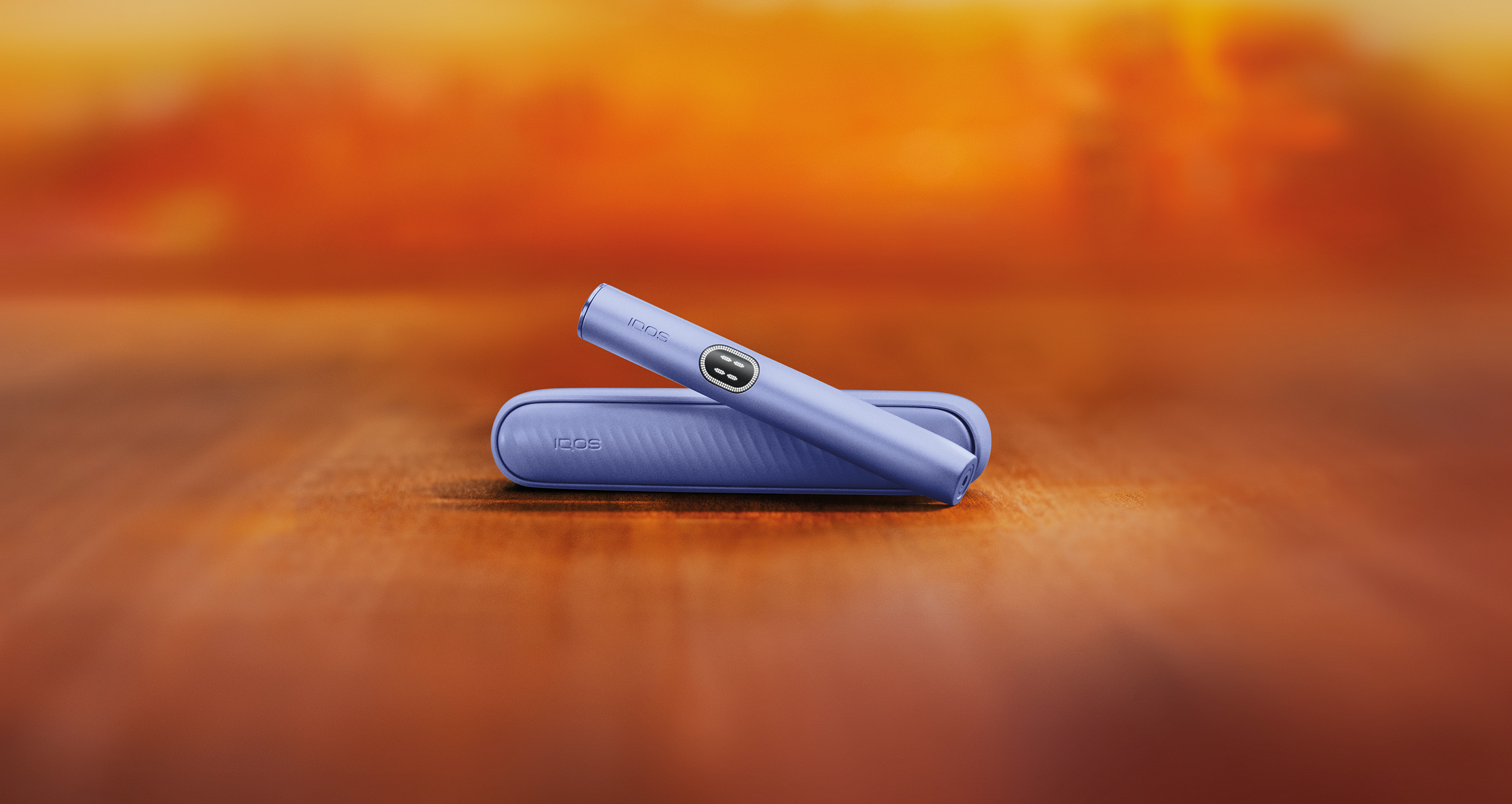 Violet IQOS ILUMA i device above its charger.