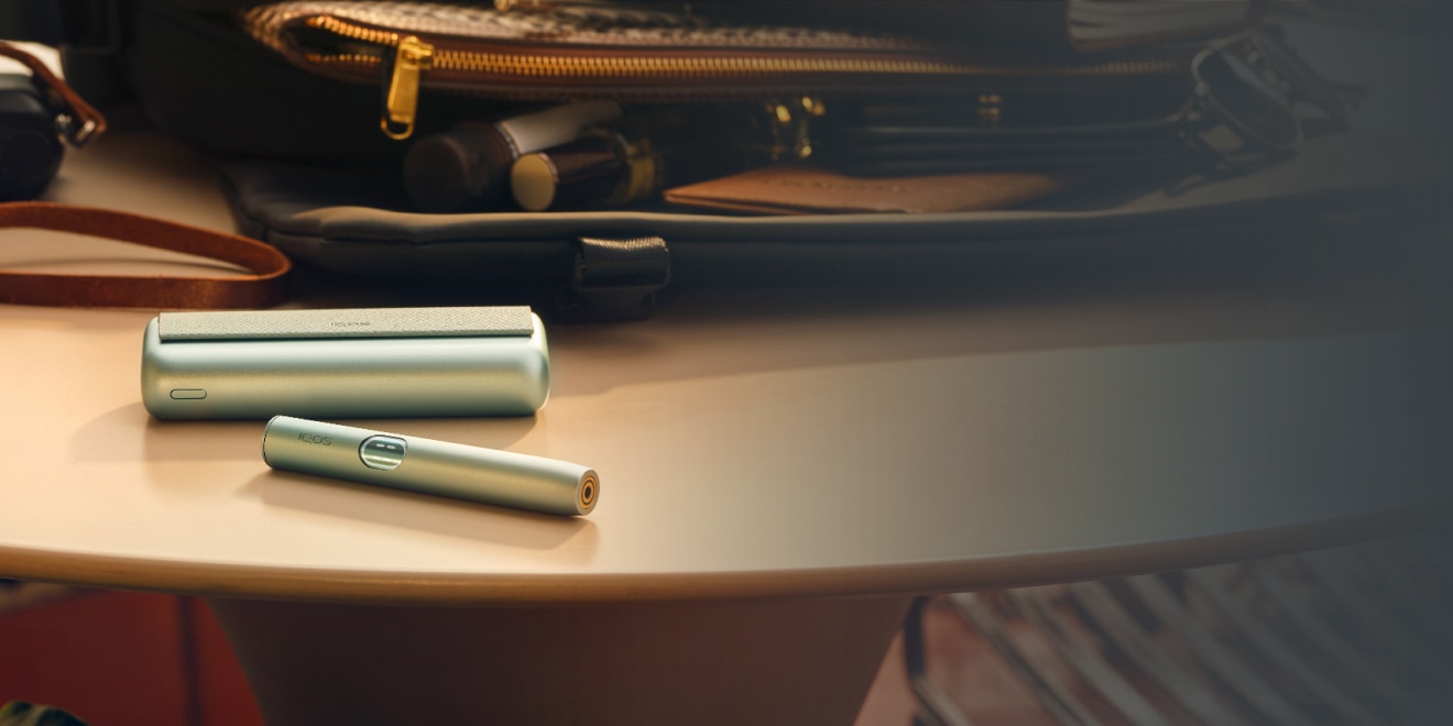 IQOS ILUMA i PRIME device on a table - with IQOS logo
