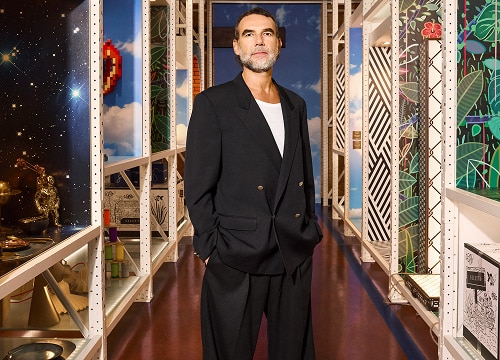 Stefano Seletti standing between two shelves with Seletti design pieces
