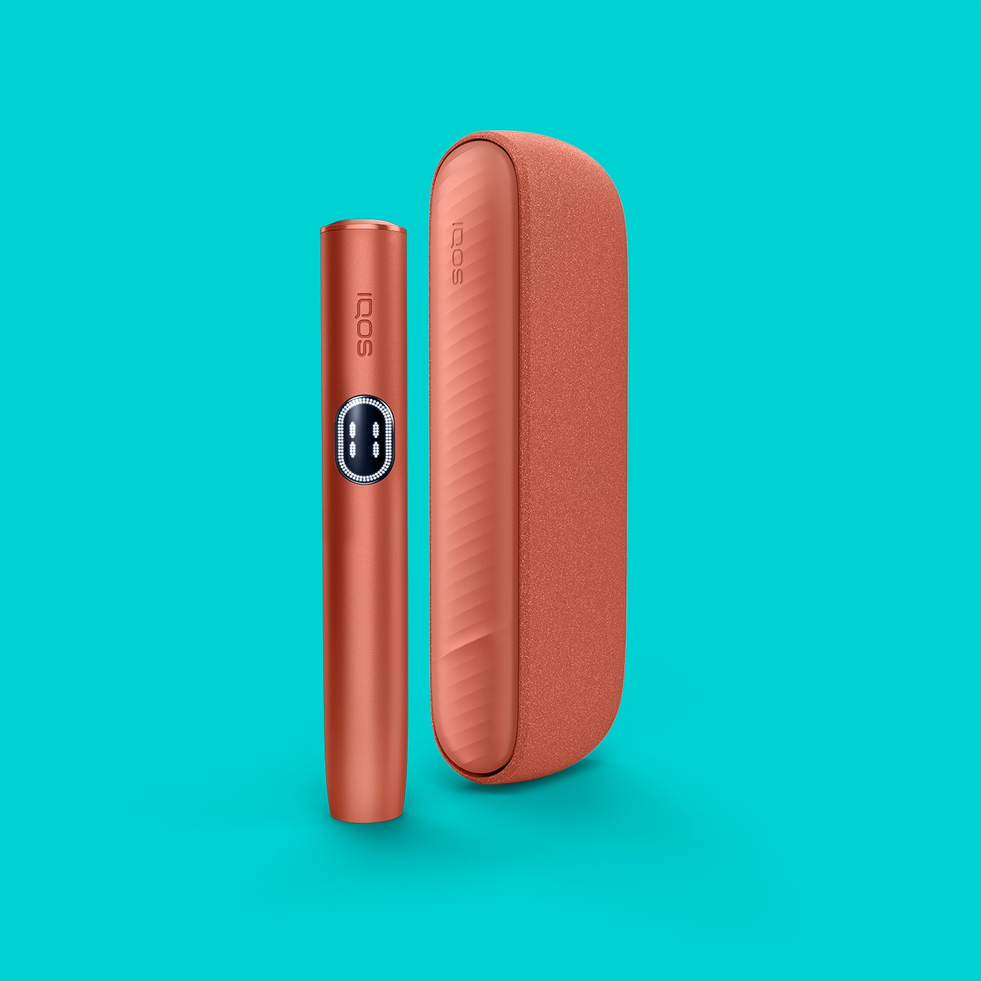 Terracotta IQOS ILUMA i device standing next to its charger, on a turquoise background